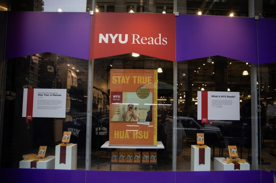 An NYU Reads display featuring a large poster of the book Stay True by Hua Hsa in a bookstore window.